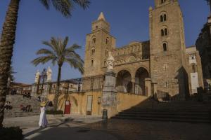 a woman in a dress standing in front of a building at Al Cortile Del Seminario in Cefalù