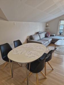 a living room with a table and chairs and a couch at Mariustova close to the airport in Ryggur +24 photos