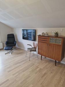a room with a dresser and a chair and a desk at Mariustova close to the airport in Ryggur