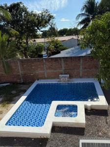 a swimming pool in a yard next to a brick wall at Rivera Solea in Llano de Los Patos