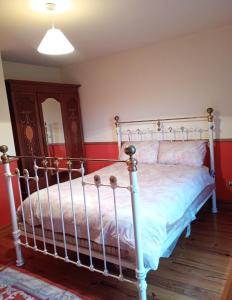 a bed in a bedroom with a red wall at Shamrock House in Fintona