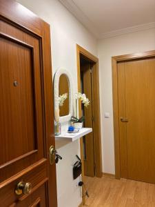 a bathroom with a wooden door and a mirror at Ponte da Illa in Isla de Arosa +7 photos