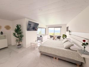 a white bedroom with a bed and a table at Ecovilla Cali in Cali