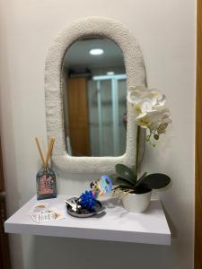 a white table with a mirror and a plant on it at Ponte da Illa in Isla de Arosa