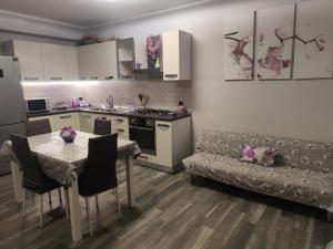 a kitchen and living room with a table and a couch at Sweet Home in Oliveri