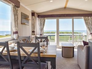 a dining room with a table and chairs and a large window at Bordeaux in Heysham