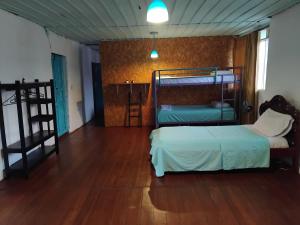 a bedroom with two beds and a wooden floor at Casa Retro Acacias Hostel in Acacías