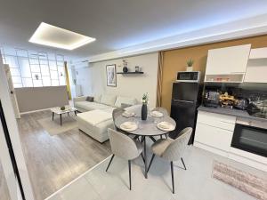 a kitchen and a living room with a table and chairs at ÁTRIUM Apartman Kaposvár in Kaposvár