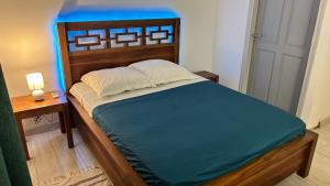 a bedroom with a bed with a wooden head board at Tropical Suite Direct Pool Access & Garden View in Baie-Mahault