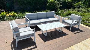 two chairs and a bench and a table on a deck at Tropical Suite Direct Pool Access & Garden View in Baie-Mahault