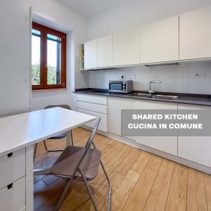 a kitchen with white cabinets and a table and chairs at Edo House Anzio - Beachfront - Fronte Mare - Affittacamere - Private Parking in Anzio +32 photos