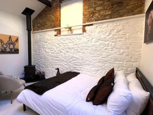 a bed in a room with a stone wall at Copper Cove at Lough Sillan House - Adults only in Shercock +19 photos