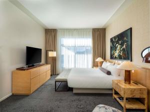 a hotel room with a bed and a flat screen tv at 21c Museum Hotel Bentonville - MGallery in Bentonville
