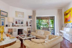 a living room with white furniture and a fireplace at Complesso Villa Le Palme in Forio d'Ischia
