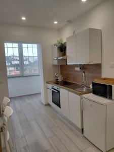 a kitchen with white cabinets and a counter top at b&b Il Margonico in Potenza +10 photos