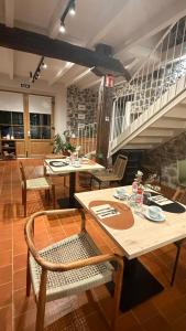 a dining room with tables and chairs and a staircase at Casa Candina in Castro-Urdiales