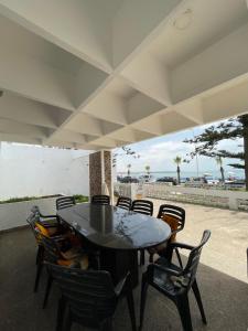 a table and chairs on a patio with the beach at Azul Blue House in Sidi Bouzid