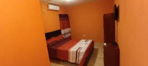 a bedroom with a bed in an orange room at Apart Fiambala alojamiento in Fiambalá
