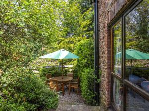 a patio with a table with an umbrella and chairs at Allerford- Ukc4920 in Timberscombe +17 photos