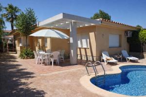 a patio with a table and an umbrella and a pool at Casa Marga - " Pet friendly - Piscina Privada - Playa - BBQ - Parking - Delta de l'Ebre - Riumar" in Riumar