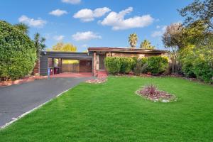 a house with a green yard with a driveway at Relax Refresh Rejuvenate Pool Cabin Garden Tree house Vintage charm in Berwick