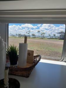 a window with a basket of toilet paper and a view of the beach at Trailer cassa Rodante in Posadas