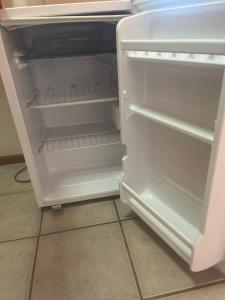 an empty refrigerator with its door open in a kitchen at DUNA Apart Hotel in Copiapó