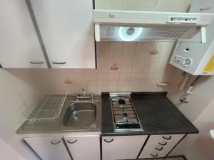 a small kitchen with a sink and a stove at DUNA Apart Hotel in Copiapó