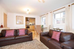 a living room with two brown leather couches at Leamington Spa Apartments in Leamington Spa