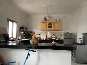 a kitchen with a black counter top and a refrigerator at Atlas House in Amizmiz