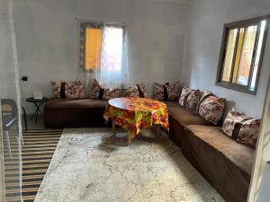 a living room with a couch and a table at Atlas House in Amizmiz