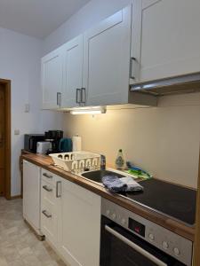 a kitchen with white cabinets and a black counter top at Appartements Am Theater - Altstadt - Parkplatz in Weimar +47 photos