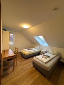 two beds in a room with a table and a desk at Appartements Am Theater - Altstadt - Parkplatz in Weimar