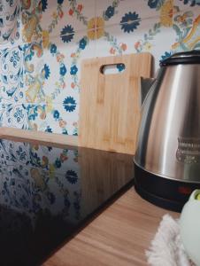 a tea kettle on a counter next to a wooden cutting board at La casa di Clizia in San Marco Evangelista