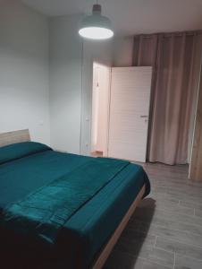 a bedroom with a green bed and a door at La casa di Clizia in San Marco Evangelista