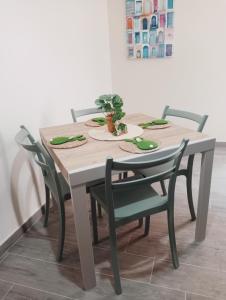 a dining room table with chairs and a table with a plant on it at La casa di Clizia in San Marco Evangelista