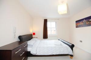 a bedroom with a bed and a dresser in it at Leamington Spa Apartments in Leamington Spa