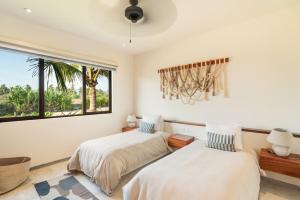 two beds in a room with a window at Casita VR08 in Zihuatanejo