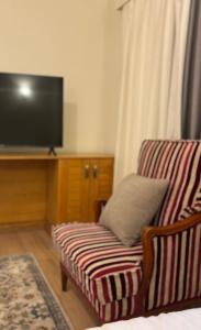 a living room with a couch and a flat screen tv at Golden Sun House II in Abu Simbel