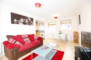 a living room with a red couch and a table at Leamington Spa Apartments in Leamington Spa