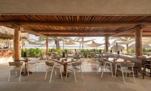 a restaurant with tables and chairs and umbrellas at Casita VR09 in Zihuatanejo