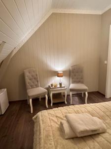 a bedroom with two chairs and a bed and a table at Trollveggen in Åndalsnes +43 photos