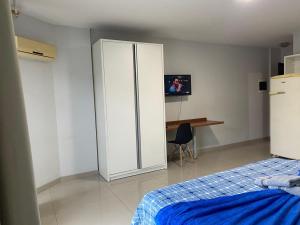 a bedroom with a white closet and a bed and a desk at 115 - Saint Sebastian Flat in Jaraguá do Sul +3 photos