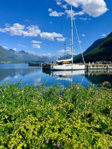 a sailboat docked at a dock on a lake at Trollveggen in Åndalsnes