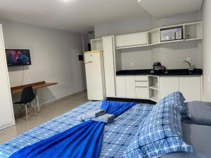 a bedroom with a blue bed with towels on it at 115 - Saint Sebastian Flat in Jaraguá do Sul