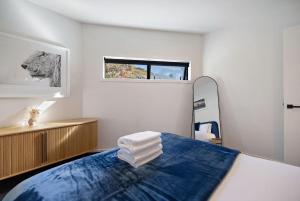a bedroom with a bed and a mirror and a window at Haven on the Lake Front in Frankton