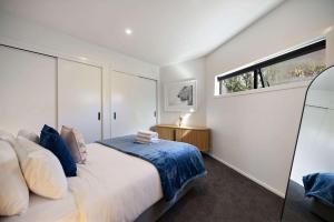 a bedroom with a large bed and a window at Haven on the Lake Front in Frankton