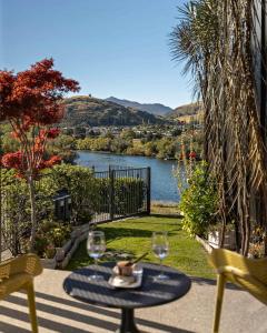 a table with wine glasses and a view of a lake at Haven on the Lake Front in Frankton