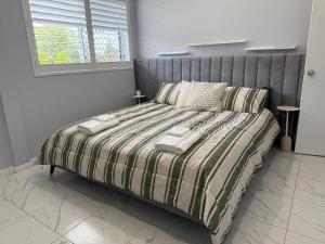 a bedroom with a bed with a striped comforter at The Green Shouse in Stanthorpe