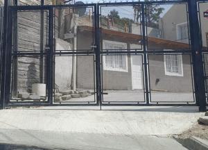 a view of a house through a glass window at Alojamiento Chamigo in Comodoro Rivadavia